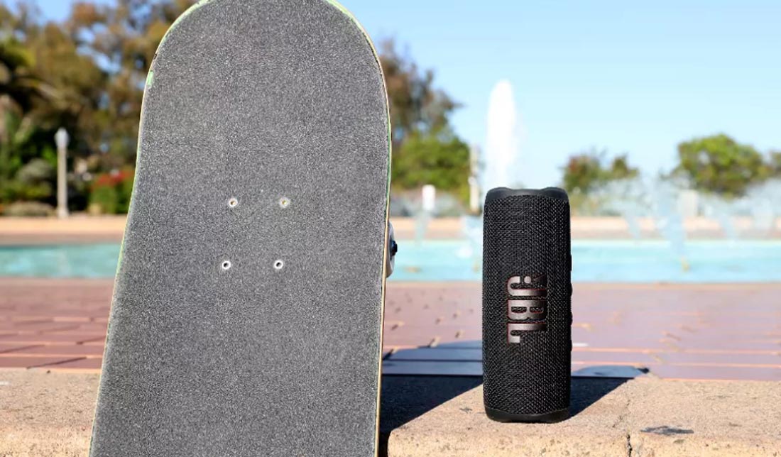 اسپیکر ‏JBL FLIP 6 رنگ مشکی درکنار اسکیت