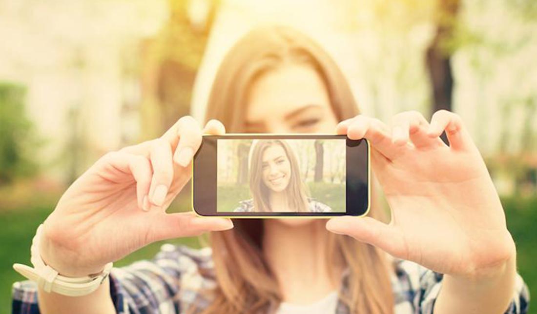 شخصی درحال سلفی گرفتن با دوربین پشت گوشی