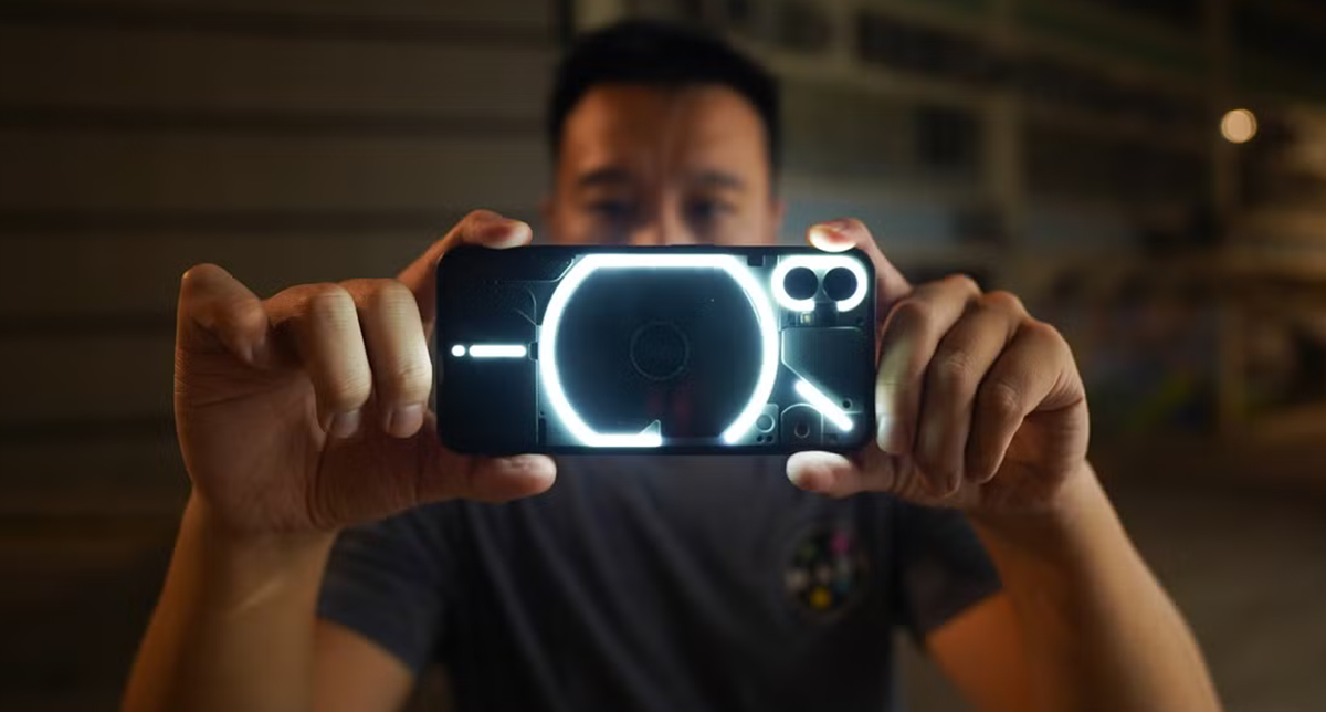 یک شخص در حال عکاسی با گوشی ناتینگ