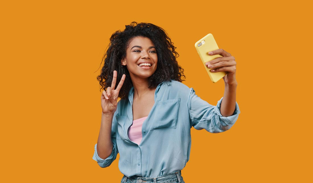 شخصی درحال ژست گرفتن با لبخند برای عکس سلفی