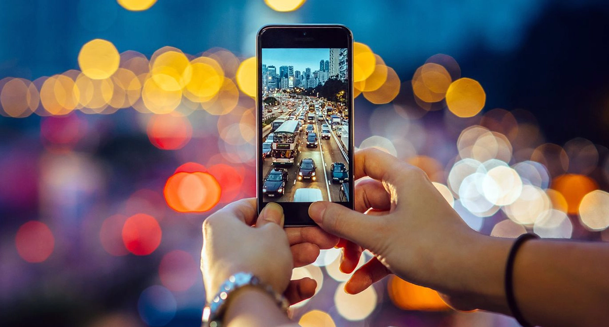 یک شخص در حال عکاسی با یک گوشی اقتصادی
